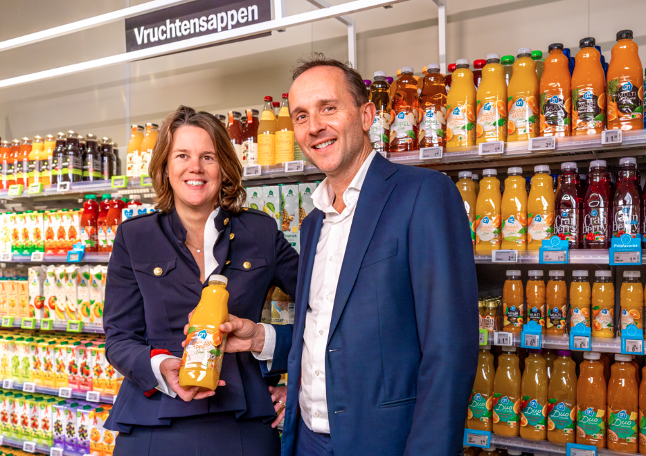 Marit van Egmond - CEO Albert Heijn at Ahold Delhaize and Tom van Aken, Avantium in front of fruit juice bottles in a supermarket